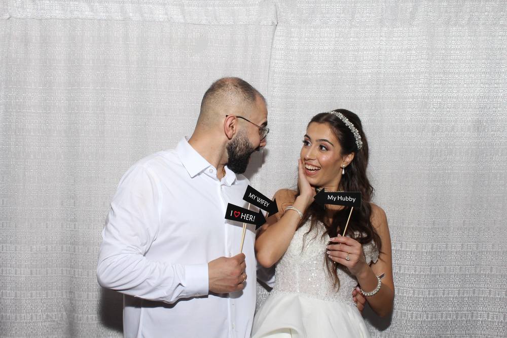 Bride and groom holding Mr and Mrs signs at the photo booth