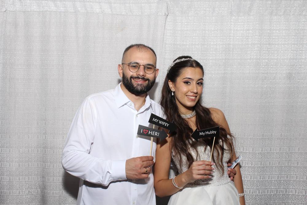 Couple smiling with props at the photo booth