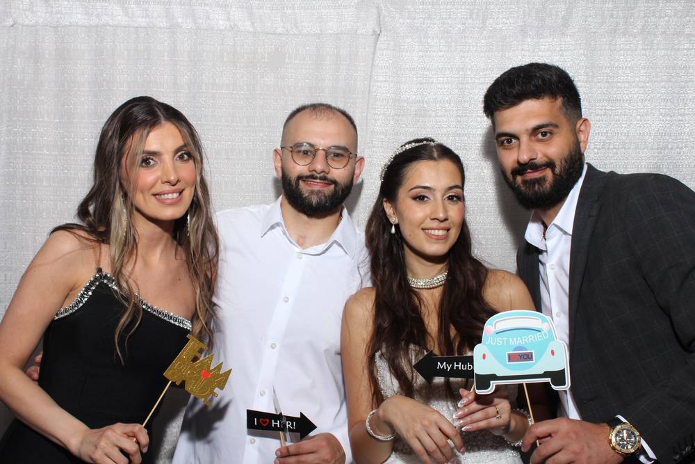 Friends posing with a cake at the photo booth