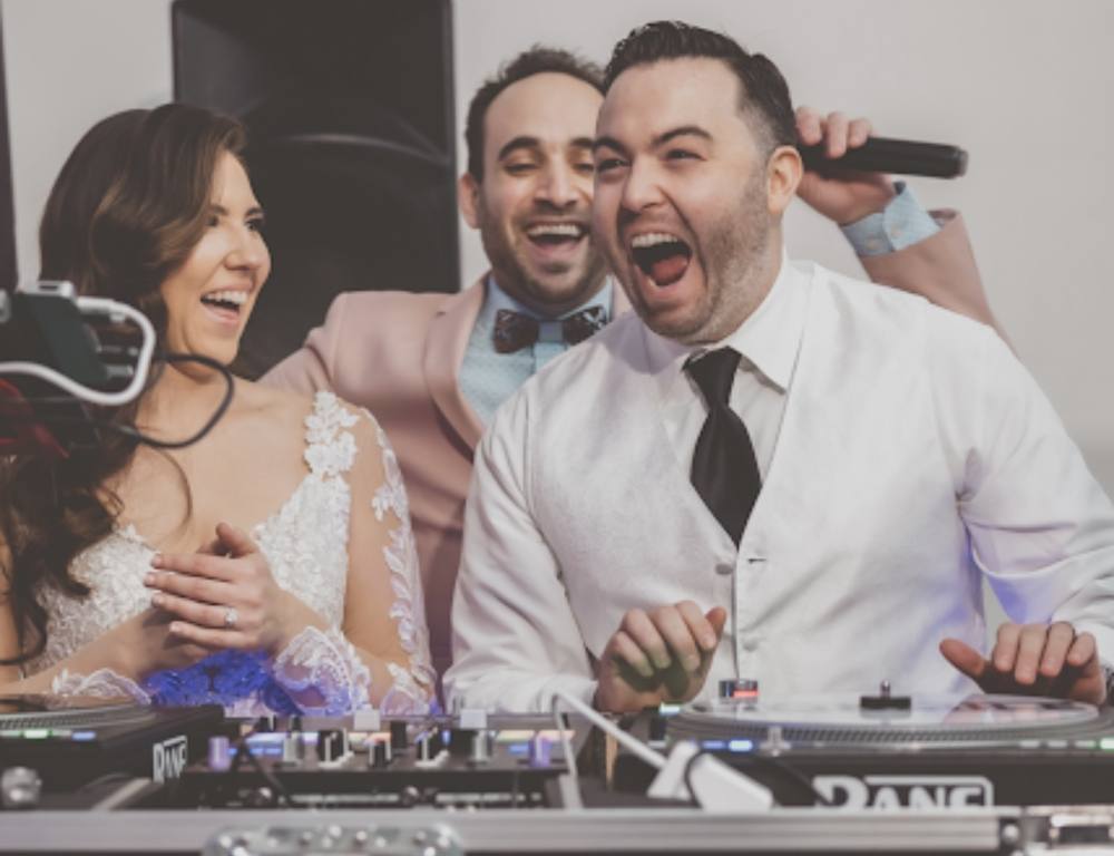 Bride and groom singing along at the DJ booth