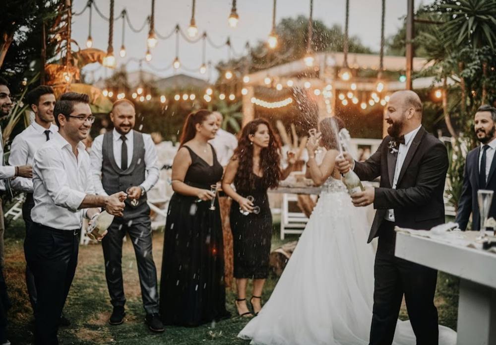 Couple celebrating with guests under string lights