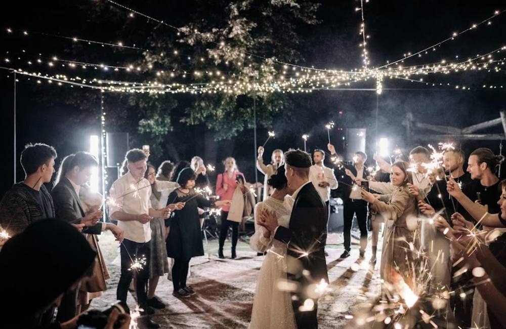 Guests celebrating under string lights at night