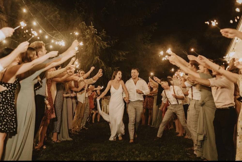 Guests dancing outdoors at night with hands in the air