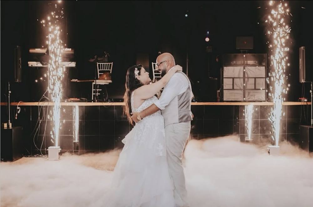 Couple kissing during their first dance between cold sparks and low cloud