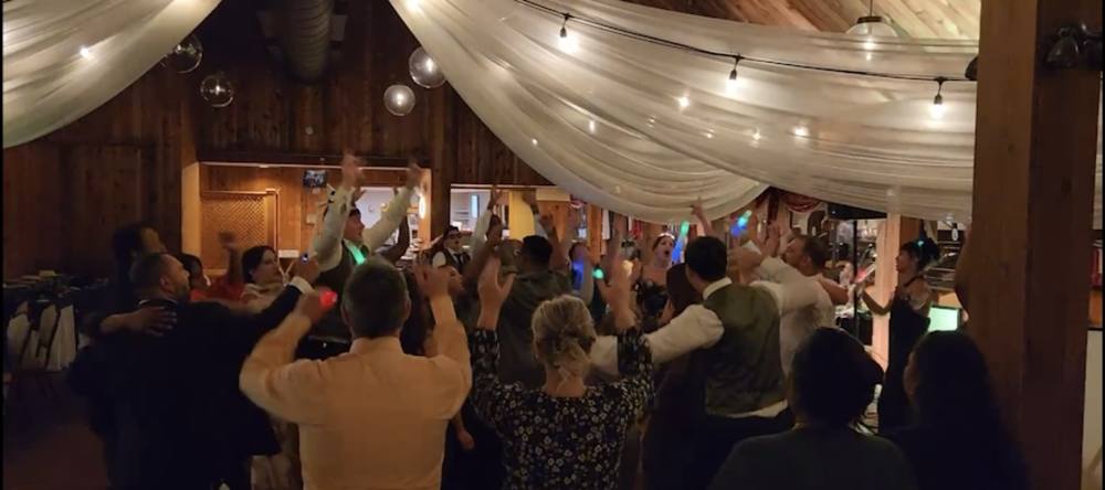 Tent reception with draped lights and a full dance floor