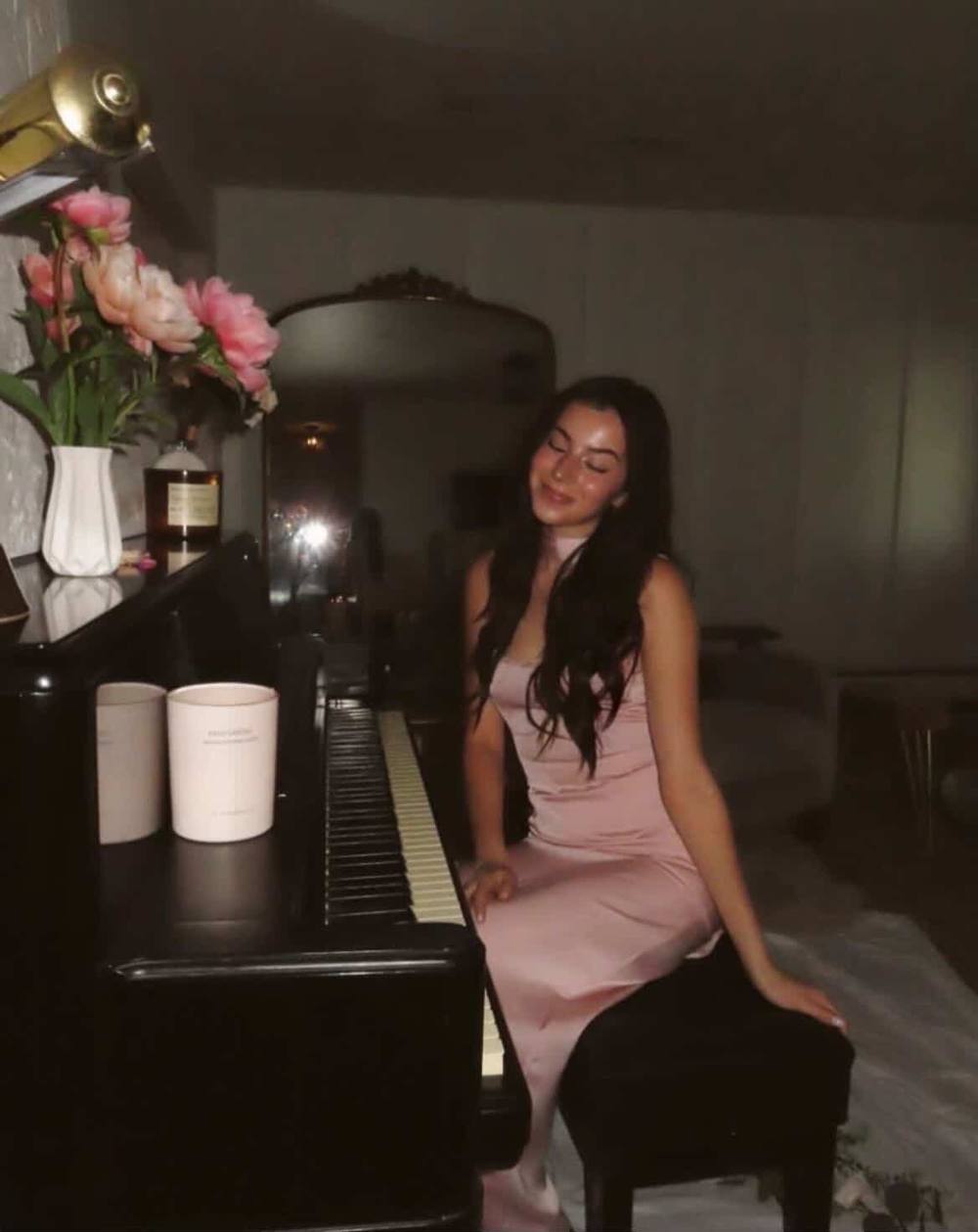 Ava, SpinVibe's pianist, smiling at an upright piano